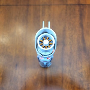 May include: A white and silver lightsaber with a gold and orange engine visible inside the hilt.