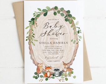 May include: A baby shower invitation featuring a watercolor design. The invitation includes the text "Baby Shower" and the name "Stella Daniels". The design incorporates a wood slice, greenery, and woodland creatures like an owl, fox, raccoon, and deer. The invitation is paired with a kraft paper envelope.