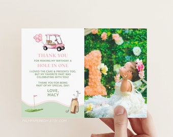 Pode incluir: Cartão dobrado com uma ilustração de carrinho de golfe rosa e o texto "THANK YOU FOR MAKING MY BIRTHDAY A HOLE IN ONE." O cartão também apresenta uma foto de uma menina com uma faixa de flores.