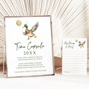 Könnte beinhalten: Eine weiße Karte mit grünem Text, der "Time Capsule 20XX" lautet. Die Karte zeigt eine Aquarell-Illustration eines Entchens, das einen Partyhut trägt und einen gelben Ballon hält. Die Karte enthält auch Anweisungen zum Schreiben einer Nachricht für eine Person, die 18 Jahre alt wird. Eine kleinere weiße Karte mit grünem Text, der "Meine Nachricht für [Name]" lautet, ist ebenfalls abgebildet. Die Karte hat einen linierten Bereich zum Schreiben einer Nachricht.
