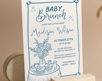 May include: Blue and white baby shower invitation with a hand-drawn illustration of a table setting with flowers, plates, and glasses. The text reads "Baby Brunch" and "Please join us as we honor Madison Wilson" with the date and time of the event, location, RSVP information, and registry details.