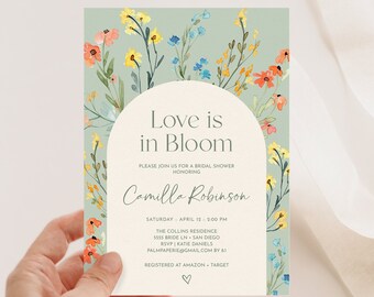 Puede incluir: Una invitación de ducha nupcial floral verde y blanca con un círculo en el centro que dice "Love is in Bloom" y el texto "Por favor, únase a nosotros para una ducha nupcial en honor a Camilla Robinson".