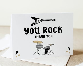 May include: A white thank you card with black text that says "You Rock" and "Thank You". The card features a black and white illustration of an electric guitar and a drum set.