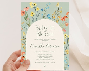 May include: A baby shower invitation with a floral design. The invitation is for Camilla Robinson and is set for August 15th at 2:00 PM. The text "Baby in Bloom" is featured in a large font at the top of the invitation.