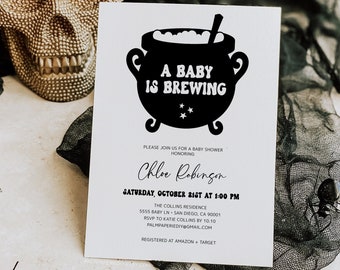 May include: A Halloween-themed baby shower invitation with the text "A Baby is Brewing" above the details. The invitation is on a white card with a black cauldron graphic. A gold skull and black spiders are in the background.