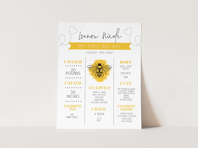 May include: A yellow and black bee illustration with a yellow background. The text "Lennon Nicole" is at the top of the image. The text "My First Bee-Day" is below the bee illustration. The text "August 10th 2020" is below the text "My First Bee-Day". The text "I Weigh 20 Pounds" is in the top left corner of the image. The text "I Stand 30 Inches" is below the text "I Weigh 20 Pounds". The text "I Love" is in the center of the image. The text "I Have 4 Teeth" is below the text "I Love". The text "Favorite Toy My Baby Doll" is below the text "I Have 4 Teeth". The text "Born Aug 10th 2019 7lbs 8oz 16in" is in the top right corner of the image. The text "I Can Say Mama & Dada Clap My Hands Play Peek-A-Boo Wave Crawl Blow Kisses" is below the text "Born Aug 10th 2019 7lbs 8oz 16in". The text "Favorite Foods Apple Sauce Coconut Yogurt Avocado Rice Puffs" is below the text "I Can Say Mama & Dada Clap My Hands Play Peek-A-Boo Wave Crawl Blow Kisses".