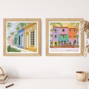 A collection of Venezuelan art prints in the form of a gallery wall featuring a beach and houses in Maracaibo.