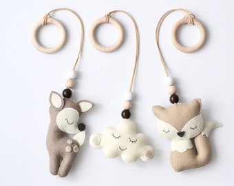 May include: Three felt animal and cloud hanging ornaments with wooden rings and beads. The ornaments feature a deer, a cloud with a smiling face, and a fox.