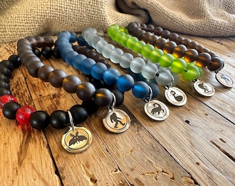 Pulsera con dijes de críptidos: Pie Grande, Hombre Polilla, Nessie, acero inoxidable
