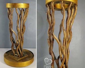 Golden stand for flowers. Stand made of natural branches of salex. Pedestal for indoor plants