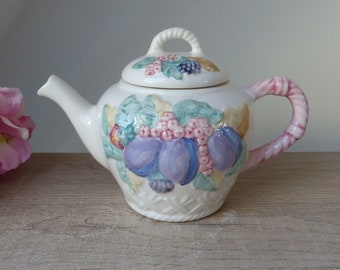 Old ceramic teapot in the shape of a basket of garden fruits with plums, strawberries and redcurrants, Mother's Day gift