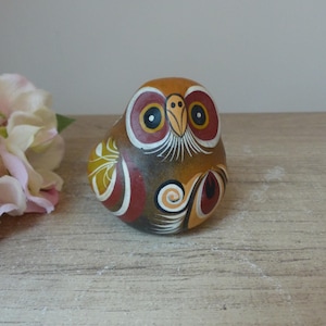 Peut inclure: Figurines d'hibou en céramique peinte à la main avec des détails bruns, orange, rouges et blancs. Le hibou a de grands yeux ronds avec des pupilles noires et un petit bec orange.