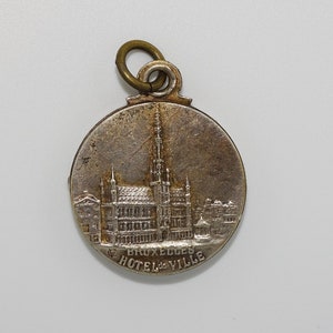 Vintage souvenir Bruxelles Hotel De Ville metal pendant/mirror fob/locket with embossed hotel landscape and shield cartouche designs
