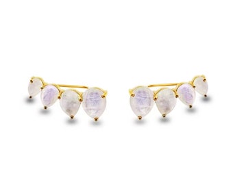 May include: A pair of gold ear cuffs with five teardrop-shaped moonstone gems.