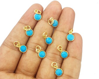 Puede incluir: Diez abalorios dorados con piedras redondas de color azul turquesa. Cada abalorio tiene un pequeño bucle para sujetarlo a un collar o pulsera.