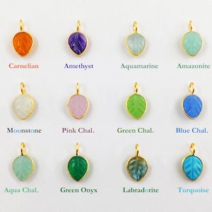 May include: Twelve gold leaf pendants with different gemstone colors, including carnelian, amethyst, aquamarine, amazonite, moonstone, pink chalcedony, green chalcedony, blue chalcedony, aqua chalcedony, green onyx, labradorite, and turquoise.