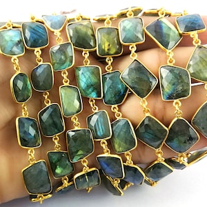 May include: A gold chain with faceted labradorite gemstone beads. The beads are a dark green with iridescent blue and gold flashes. The chain is approximately 18 inches long.