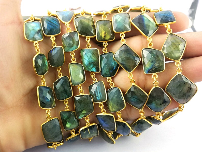 May include: A gold chain with faceted labradorite gemstone beads. The beads are a dark green with iridescent blue and gold flashes. The chain is approximately 18 inches long.