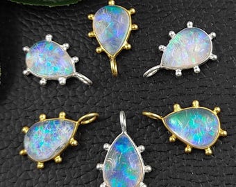 May include: Six teardrop-shaped opal pendants with gold and silver settings. The pendants have a beaded edge and a loop for attaching to a chain or cord.