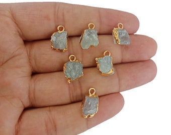 May include: Six gold-plated aquamarine crystal pendants. Each pendant is a raw, irregular shape with a gold bail.