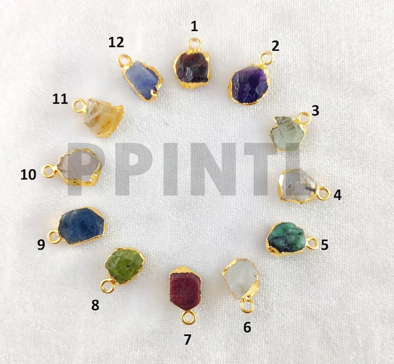 May include: A collection of twelve gemstone pendants with gold-colored metal edging. The gemstones vary in color, including purple, green, blue, and yellow. Each pendant has a small loop for attaching to a chain or other jewelry component.