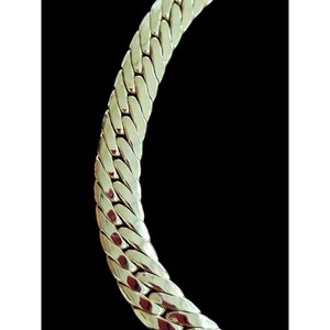 May include: A gold chain necklace with a thick, textured, interwoven design.