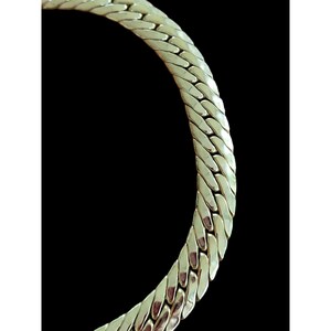 May include: A silver chain necklace with a textured, woven design.