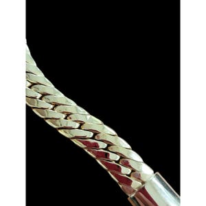 May include: A gold chain necklace with a thick, textured, curb link design.