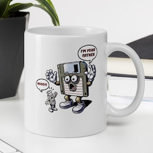 Könnte beinhalten: Weiße Keramiktasse mit einer Cartoon-Illustration einer Diskette, die zu einem USB-Stick sagt: "Ich bin dein Vater", und der USB-Stick sagt: "Nooo!!!".