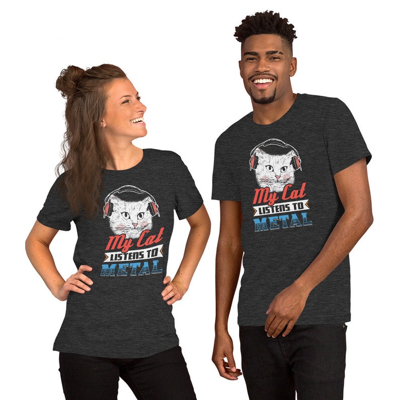 May include: Two people wearing dark grey t-shirts with a white cat wearing headphones and the text "My Cat Listens To Metal".