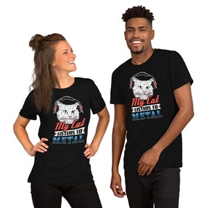 May include: Two people wearing black t-shirts with a white cat wearing headphones and the text "My Cat Listens To Metal".