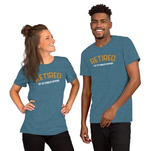May include: Two people wearing teal blue t-shirts with the text "Retired Not My Problem Anymore" in orange and white lettering.