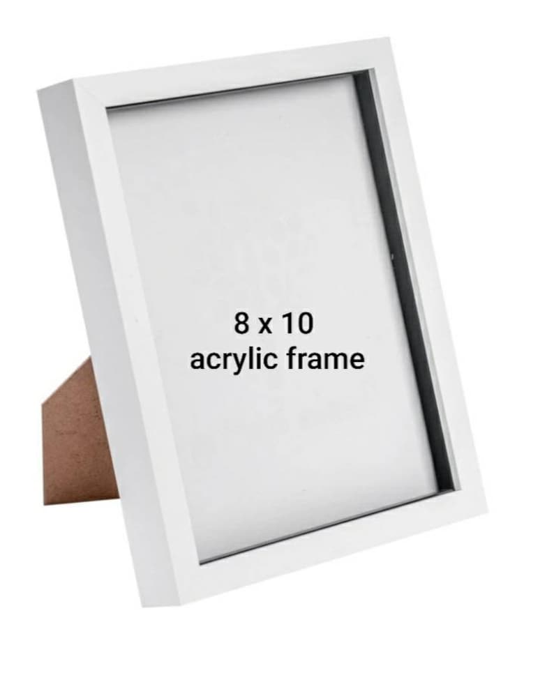 May include: White 8 x 10 inch acrylic picture frame with a black mat. The frame is standing on a wooden easel.