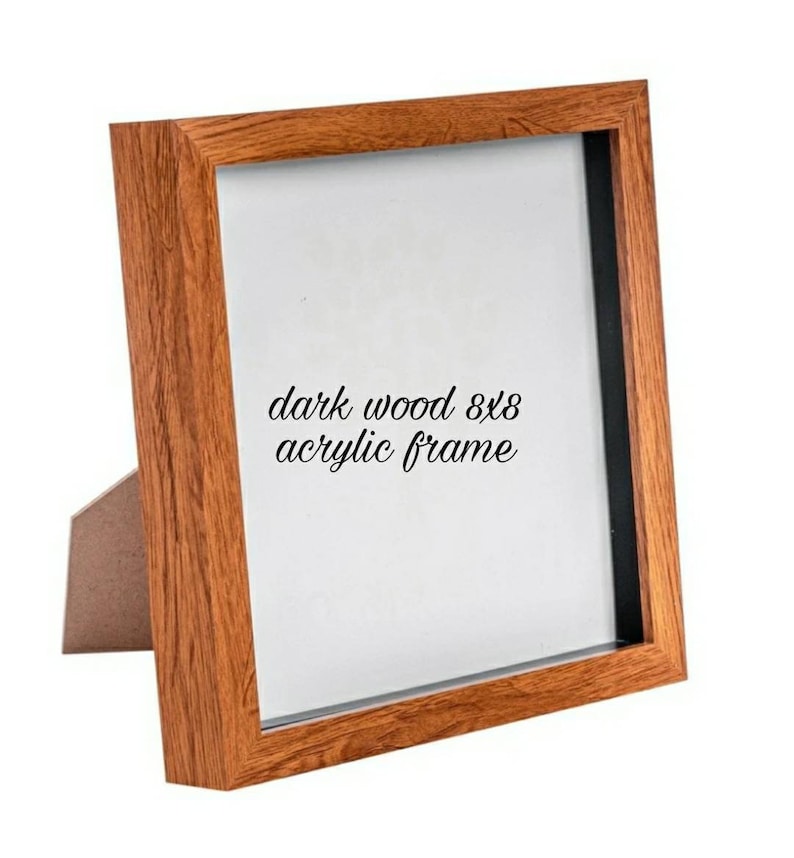 May include: Dark wood 8x8 acrylic frame. The frame has a brown wood finish and a black mat. The frame is standing on a white surface.