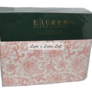 Puede incluir: Un juego de sábanas tamaño king, con estampado paisley blanco y rosa, de la marca Lauren Ralph Lauren. El embalaje muestra el nombre de la marca y las palabras "King Sheet Set".