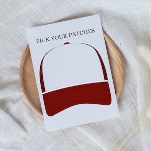 Könnte beinhalten: Eine weiße und rote Baseballkappe mit dem Text "PICK YOUR PATCHES" auf der Vorderseite. Die Kappe hat einen leeren Platz auf der Vorderseite, um Patches hinzuzufügen.