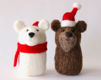 May include: Two handmade felt animal ornaments. One is a white polar bear with a red scarf and a black nose. The other is a brown bear wearing a red and white Santa hat. Both are Christmas-themed decorations.