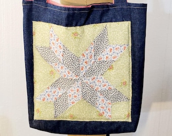 Könnte beinhalten: Eine Denim-Tragetasche mit rosa Futter und einem Patchwork-Sternmuster in Grün-, Weiß-, Schwarz- und Rosatönen.
