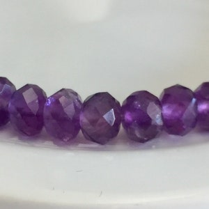 May include: A strand of faceted amethyst beads in a deep purple colour.