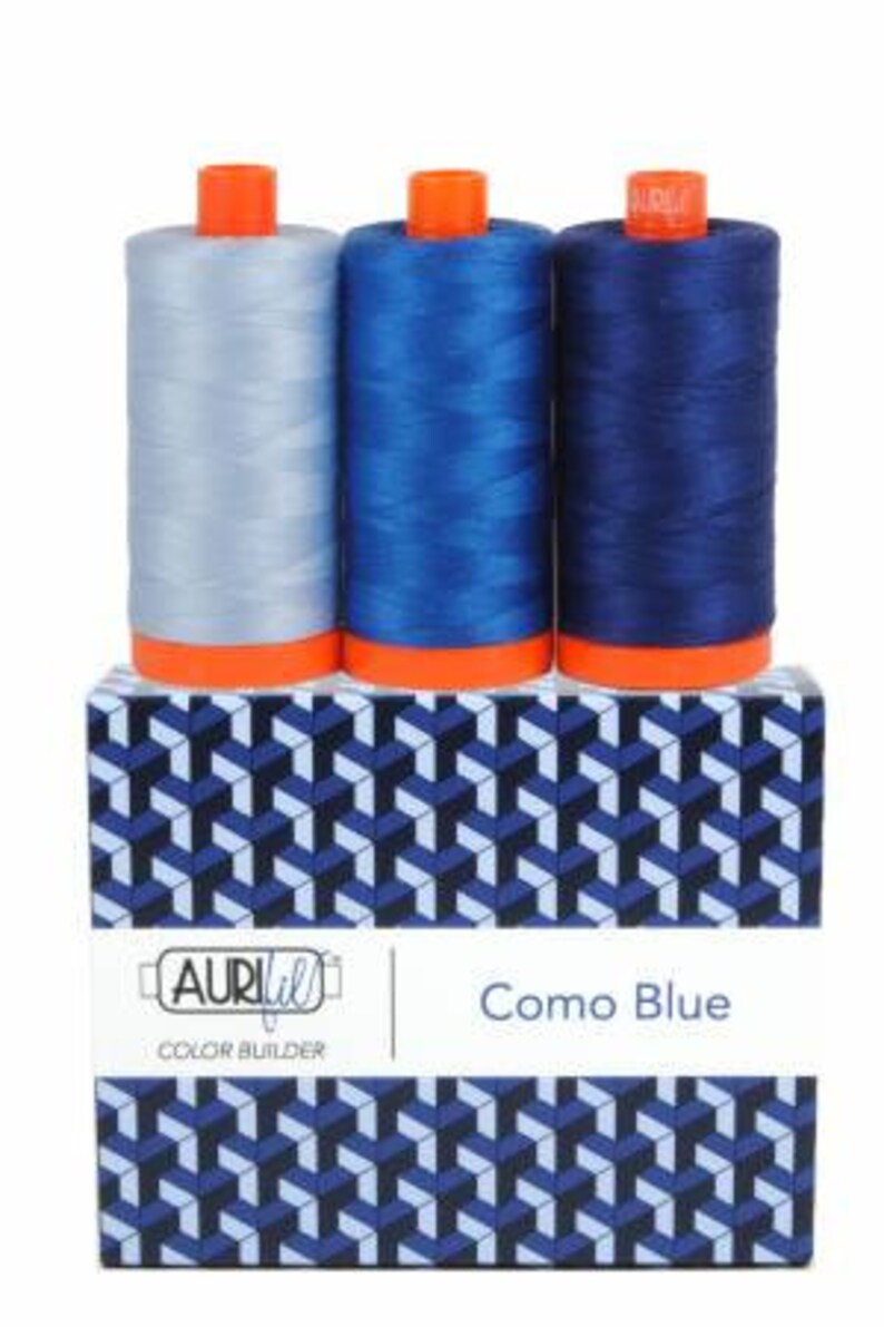 May include: Three spools of thread in shades of blue, labeled "Como Blue" and "Aurifil Color Builder".
