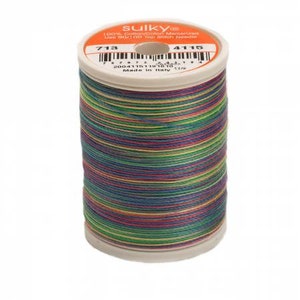 May include: A spool of Sulky brand thread, featuring a vibrant array of colors including green, purple, and yellow. The thread is wound around a white spool with an orange label. The label displays the number 713 and 4115.