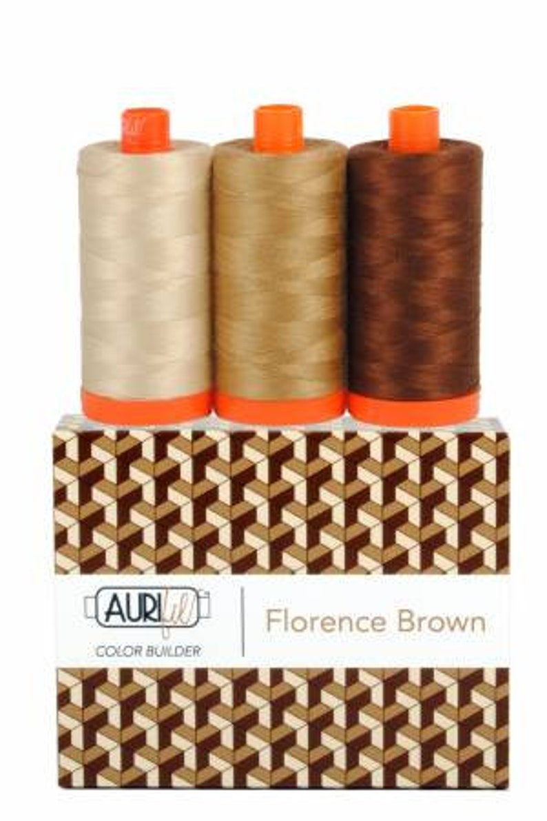 May include: Three spools of thread in beige, brown, and dark brown shades. The spools are labeled "Aurifil Color Builder Florence Brown".
