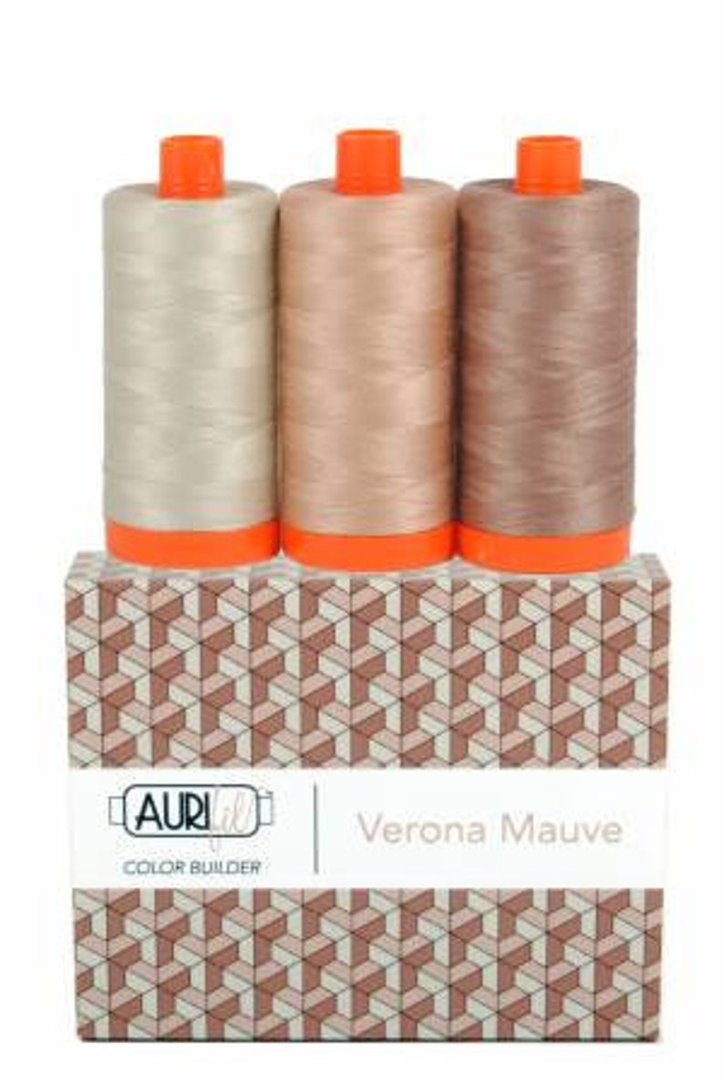 May include: Three spools of thread in shades of beige, light brown, and brown, labeled "Verona Mauve" and "Color Builder" on a box with a geometric pattern.