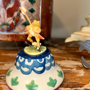 Beatrix Potter Fisher Frog with his fishing pole figurine secured to a stand
