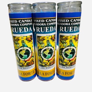May include: Three glass candle jars with blue and yellow labels. The labels feature a tarot card image of the Wheel of Fortune with the text "Rueda" and "De Wereld" in Spanish and Dutch. The text "Fixed Candle" and "Reladora Compues" is also on the label.