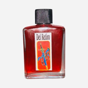 May include: A rectangular glass bottle filled with a red liquid, featuring a black cap. The label reads "Del Retiro" and displays a colorful illustration of a sword and other elements. The bottle has a clear, transparent appearance.