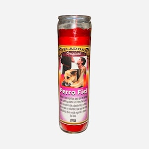 May include: A red glass candle with a label featuring the text "VELADORA Original" and "Perro Fiel". The label includes an image of a person and a dog. The candle is cylindrical and has a wick.