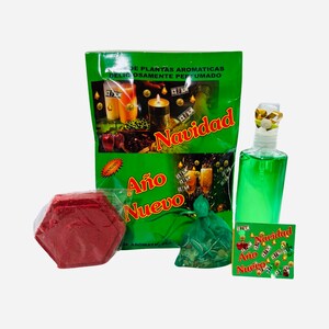 May include: A green and gold Christmas and New Year's gift set with a red hexagonal candle, a green pouch with herbs, a green bottle of liquid, and a green and gold card with the words "Navidad Año Nuevo" on it.