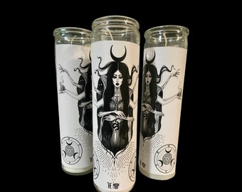 May include: Three white pillar candles with black and white illustrations of a woman with multiple arms and a crescent moon. The text "The Moon" is printed on the bottom of the candle.
