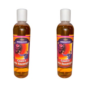 May include: Two amber glass bottles with a purple and orange label. The label says "Original" and "Contra mis Enemigos". The bottles are filled with a clear liquid.